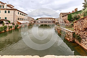 View to theÂ Renaissance pool with green mineral spring water and Loggiato di S.Caterina inÂ Bagno Vignoni, Tuscany, Italy